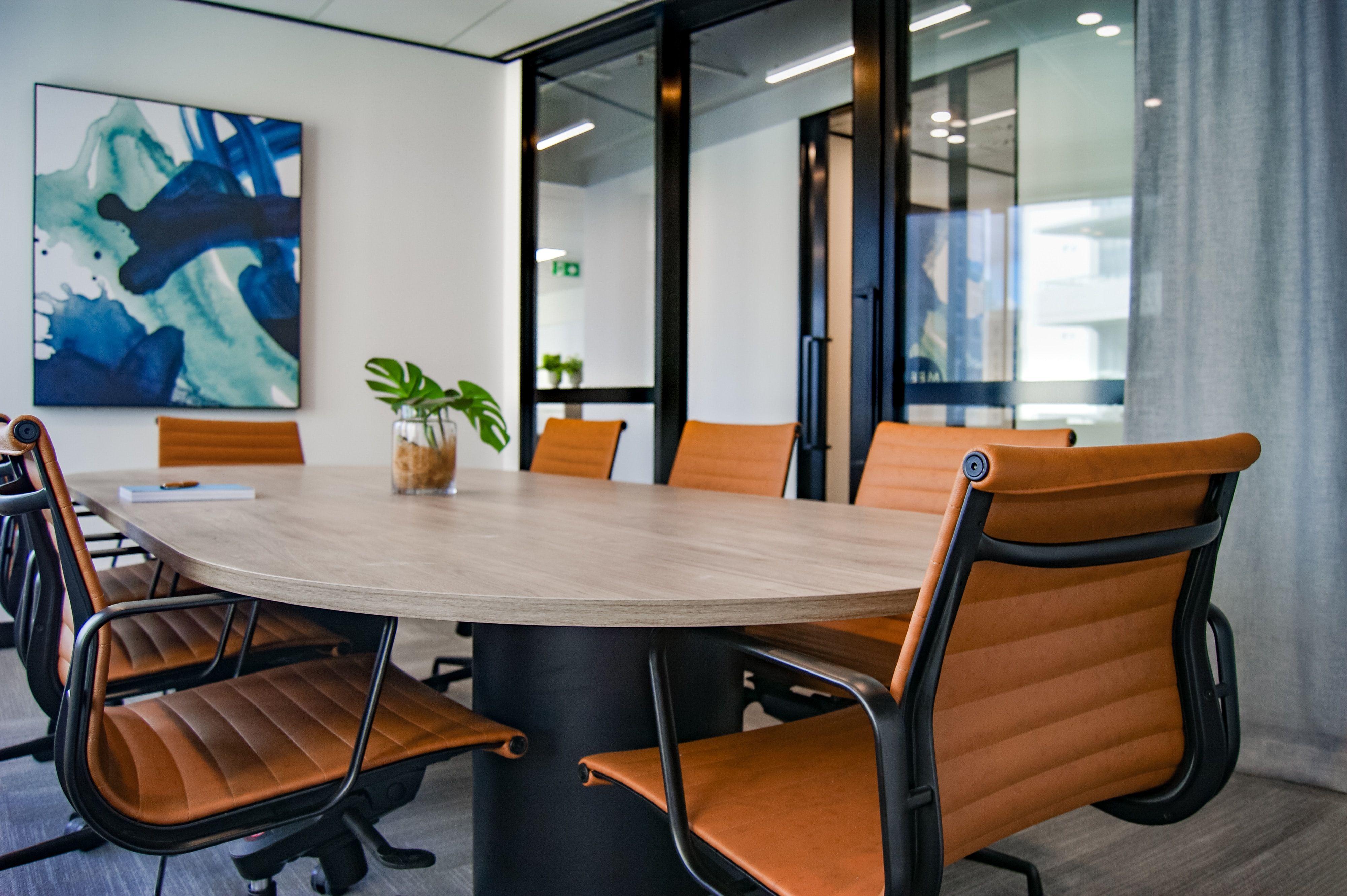 A picture of a hallway in a shared office space building. You can see office furniture behind glass walls.